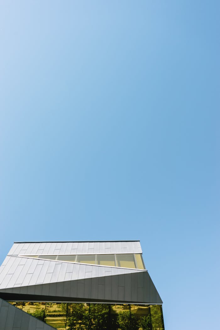 Low angle view of a modern building facade against a clear blue sky.